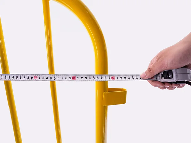 A QC worker is measuring the width of crowd control barrier.