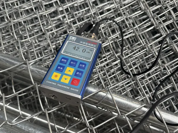 The surface coating thickness of the customized chain link gates is being inspected, with the instrument displaying a measured value of 42.0 μm.