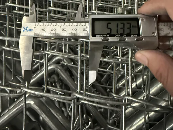 A worker is measuring the mesh width of the customized chain link gates with a vernier caliper.