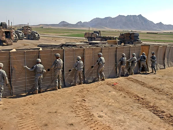 Several solders are stand behind of the defensive barriers.