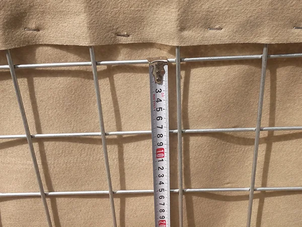 A QC worker is measuring the mesh size of defensive barriers.