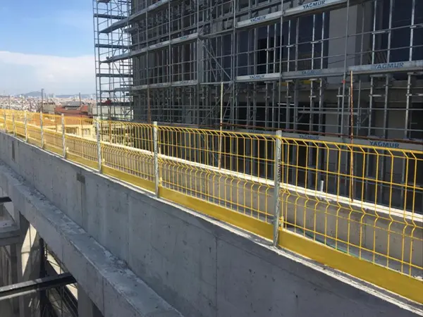 The yellow edge protection fences are installed of the edge of high-rise building floor.