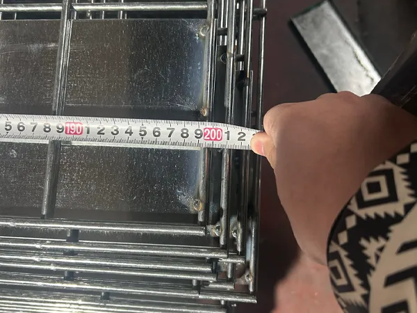 Measuring edge protection fence panel dimension with tape.