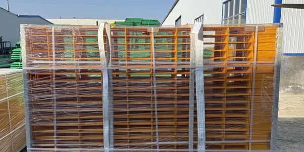 A batch of yellow edge protection fences packed with plastic film and straps, placed on the factory floor.