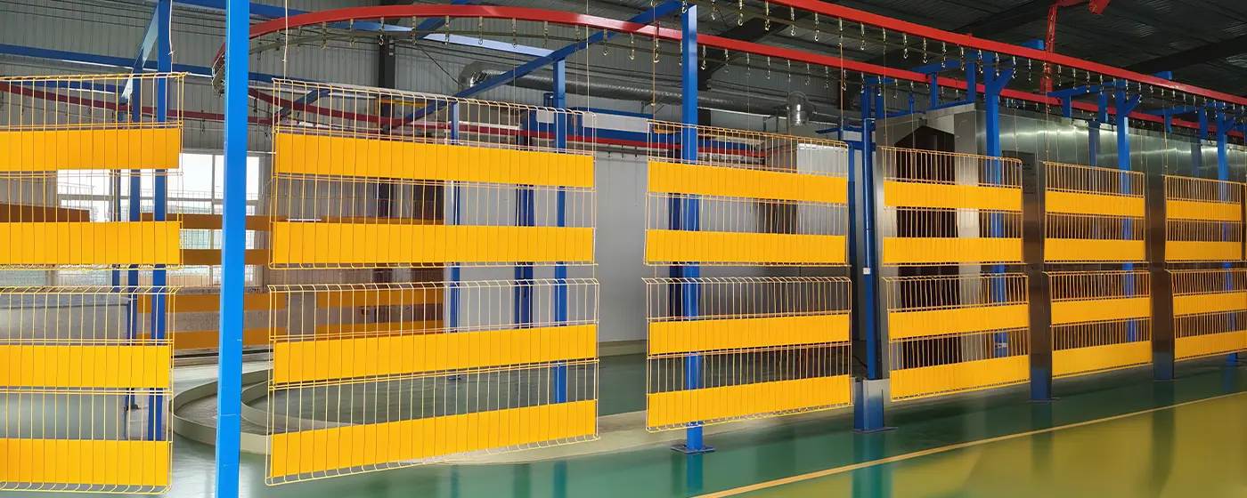 The yellow edge protection fences are hanging on the powder coating line.