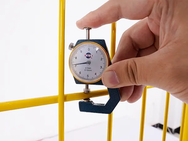 A QC worker is measuring the wire diameter of edge protection fence.