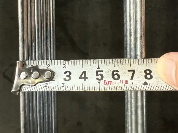 Worker measuring edge protection fence mesh width