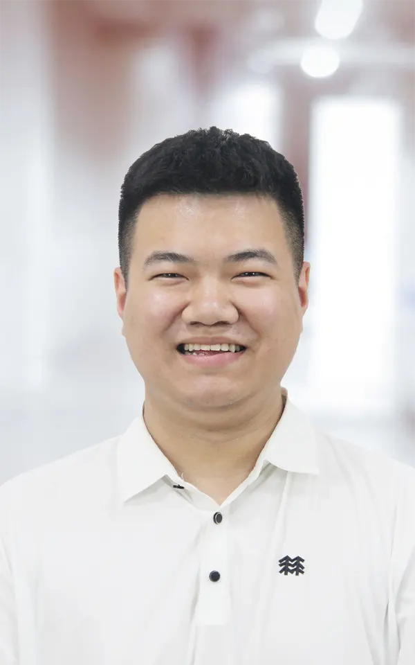 A man employee is smiling.