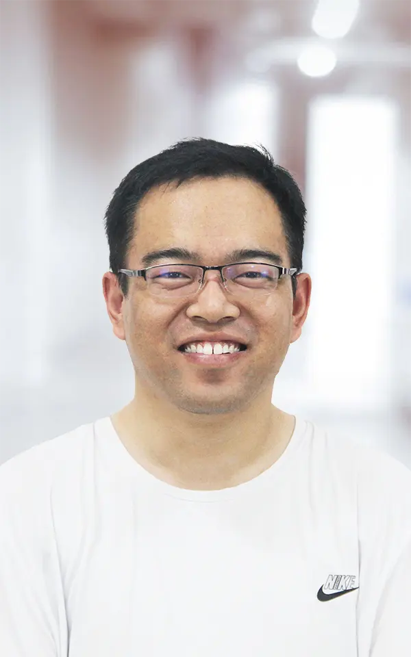 A man employee is smiling.