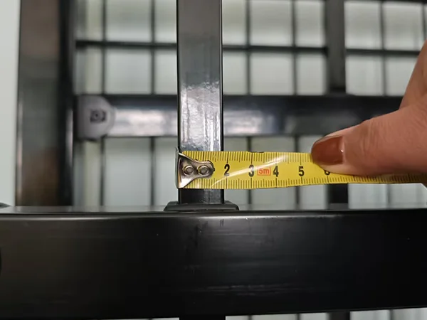 A QC worker is measuring the tubular size of sliding fence gate.