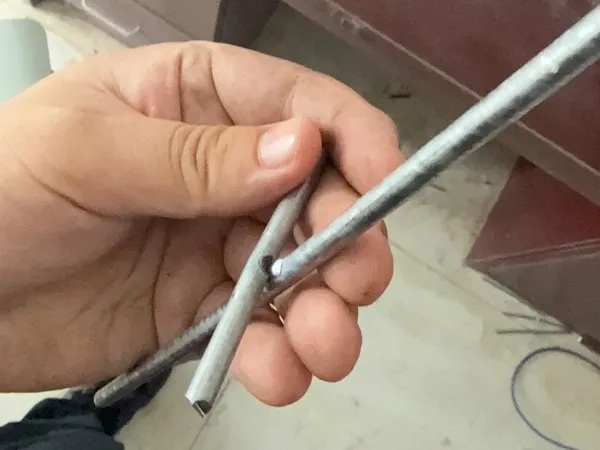 Fence wire tensile strength test specimen with welded wire joint.