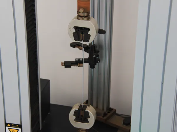Fence wire tensile strength test using a universal testing machine.