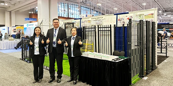 Our CEO, sales manager and sales representative taking photo at the front of the exhibition booth.