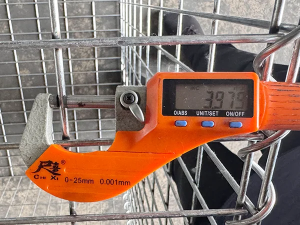 A QC worker is measuring the cross wire diameter of welded gabion retaining wall.