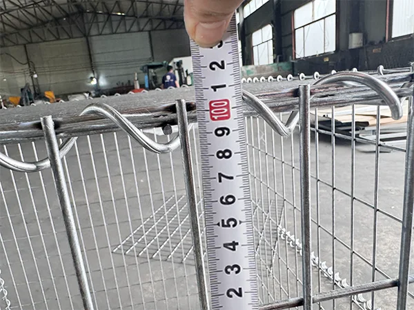 A QC worker is measuring the height of welded gabion retaining wall.