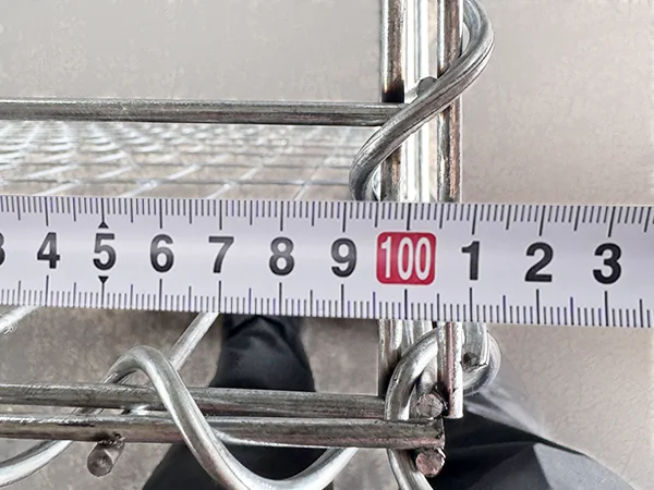 A QC worker is measuring the length of welded gabion retaining wall.