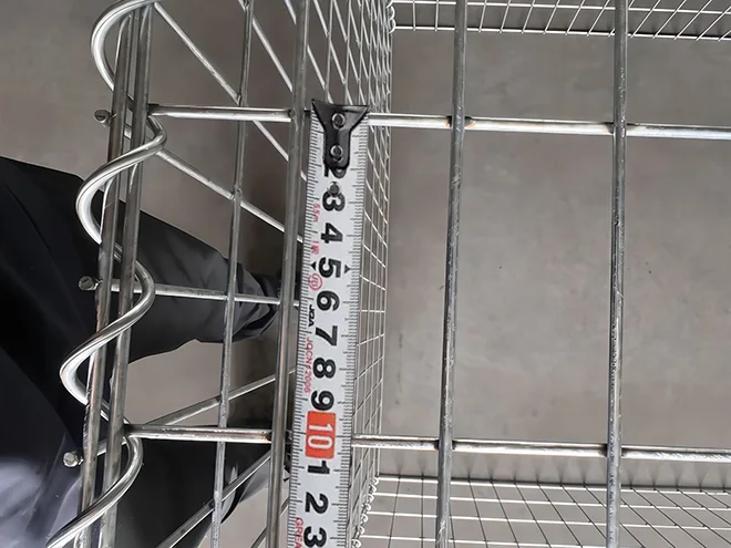 A QC worker is measuring the mesh size of welded gabion retaining wall.