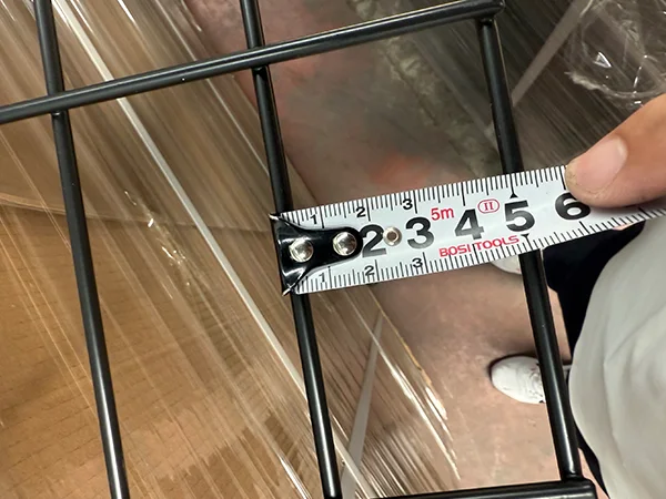 A QC worker is measuring the mesh size of gabion wall
