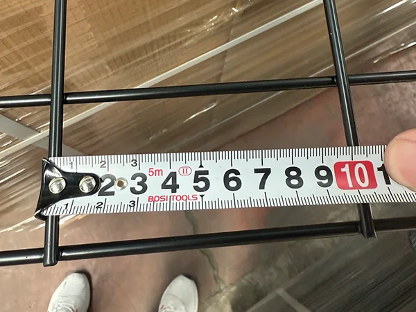 A QC worker is measuring the mesh size of gabion wall