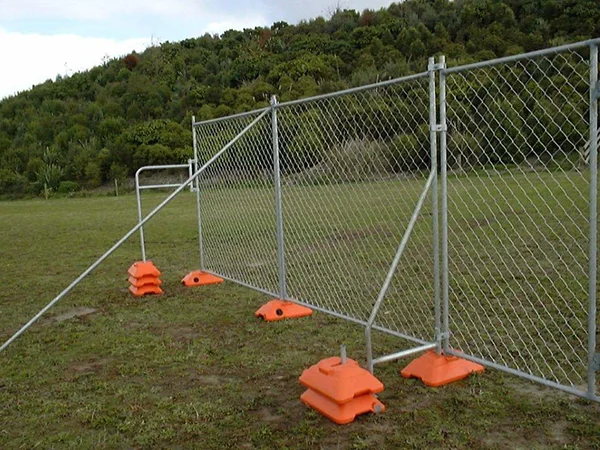 The Galvanized chain link temporary fencing panels with bracing are installed on the grassland