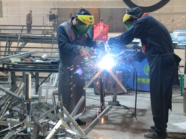 Two workers carrying out welding work in the Giant Fence workshop.
