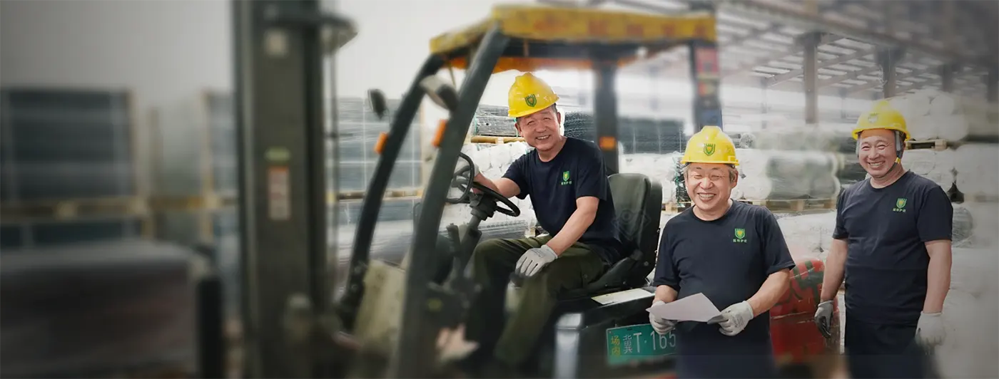Three workers are smiling in the warehouse.