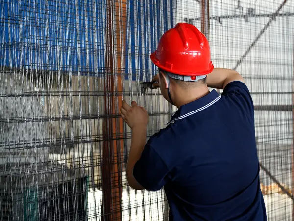 A QC worker is inspecting the wire diameter of welded panel after PE coating.