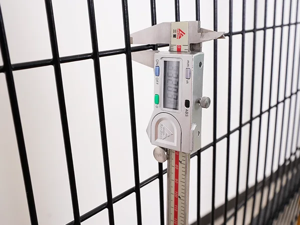 A QC worker is measuring the wire diameter of machine guarding fence.