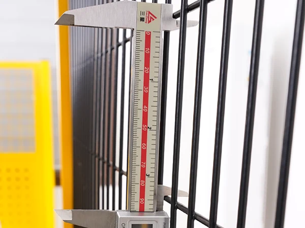 A QC worker is measuring the mesh size of machine guarding fence.