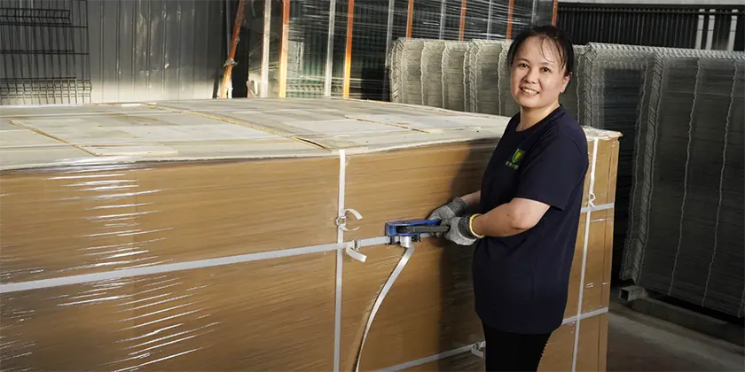 A packaging worker, a forklift and several security fence pallets.