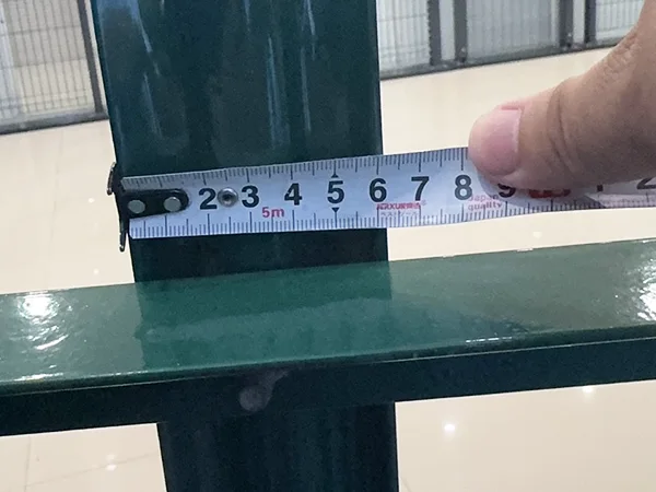 A QC worker is measuring the pale width of palisade fence.