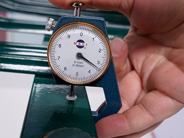 A QC worker is measuring the post thickness of palisade fence.