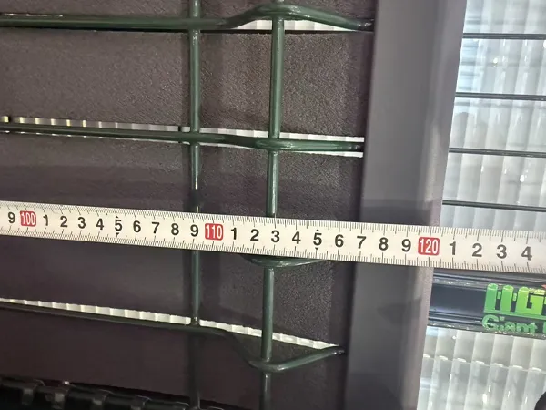 A QC worker is measuring the height of privacy fence.