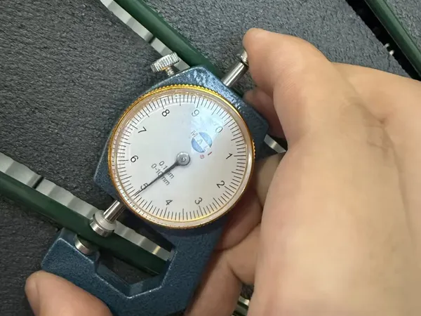 Wire diameter measurement of a privacy fence panel with a caliper.