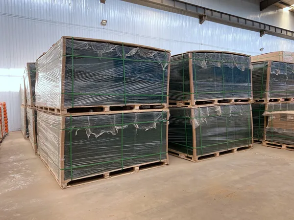 Privacy fence panels packed and stacked on wooden pallets.