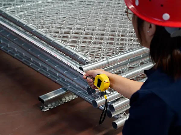 A QC worker is inspecting the wire diameter of 3d mesh fence.