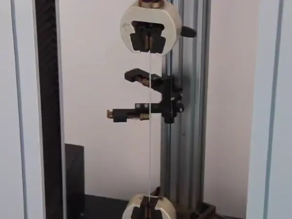 A QC worker is inspecting the tension strength of steel wire.