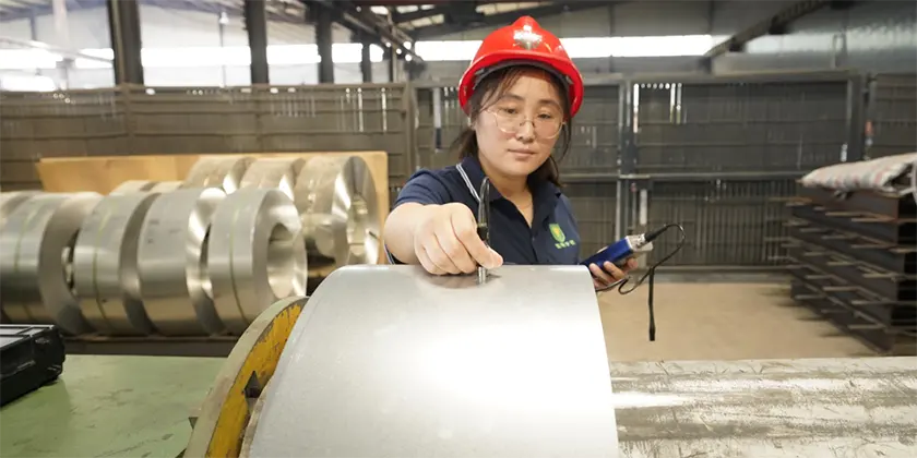 A QC worker is testing the zinc coating thickness of steel plate