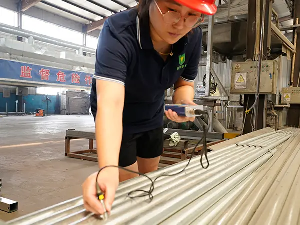 A QC worker is inspecting the zinc thickness of 3d mesh fence.