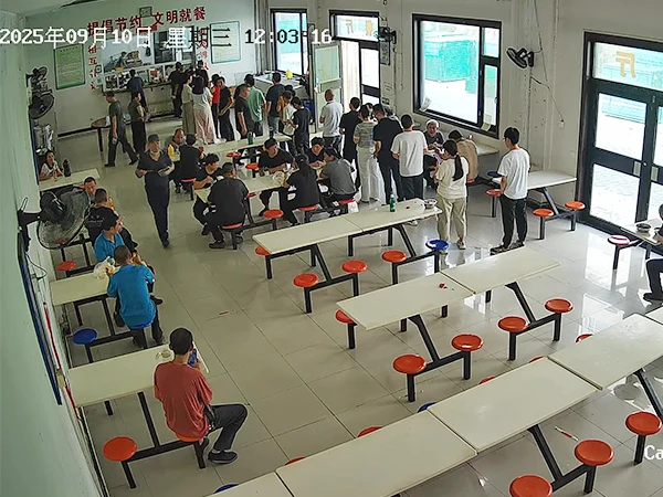 Several staffs are having meals in the canteen.