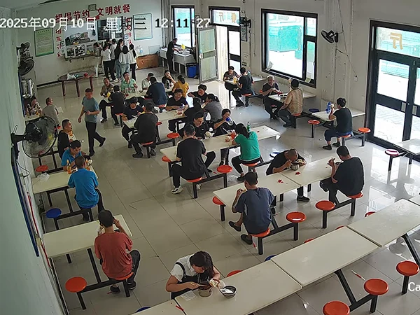 Several staffs are having meals in the canteen.