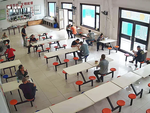 Several staff are having meals in the canteen.