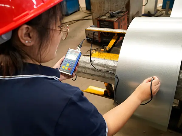 A qc worker is testing the zinc coating of steel plate.