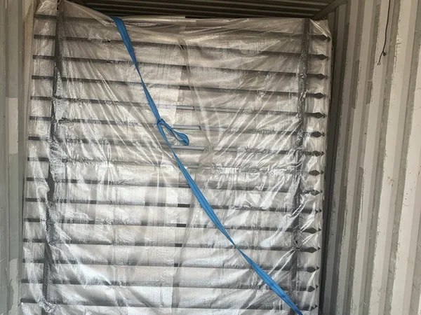 Several pieces of steel tubular fence panels in the container.