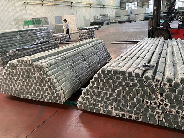 Several pieces of steel tubular fence post on the ground.