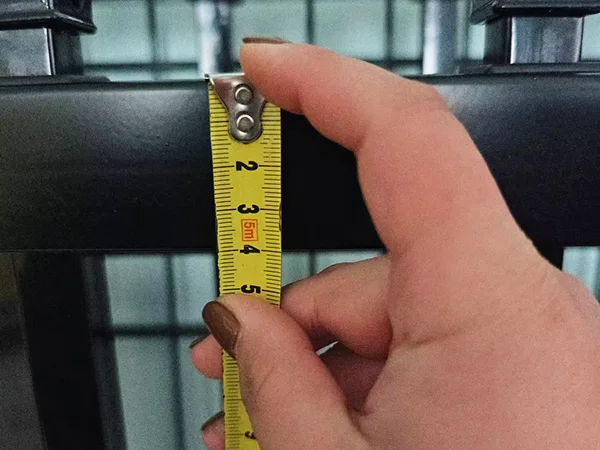 A QC worker is measuring the rail size of steel tubular fence.