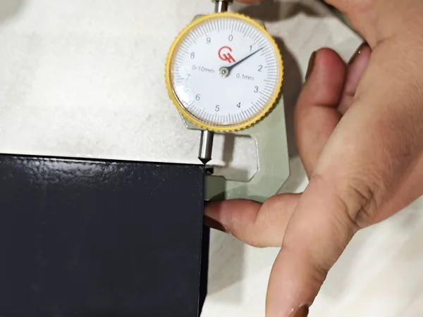 A QC worker is measuring the rail thickness of steel tubular fence.