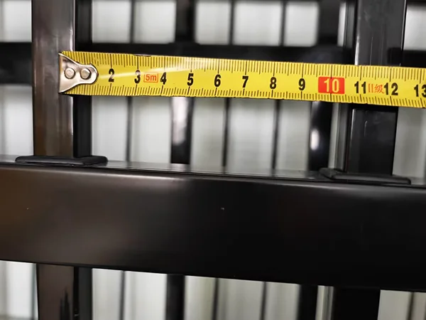 A QC worker is measuring the tubular spacing of steel tubular fence.