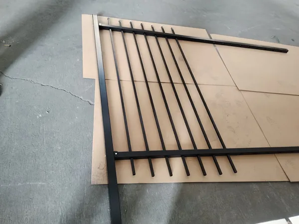 Matte black finished steel tubular fencing panel on workshop floor