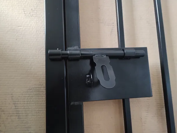 Close view of slide lock bolt on black coated steel tubular fencing gate